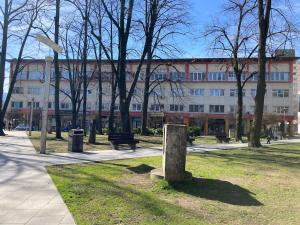 un bâtiment dans un parc avec un banc et des arbres dans l'établissement Penthouse stan 80m2, terasa 36m2, garaža... centar Banja Luke - gradski park, à Banja Luka