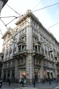 a large building with people walking in front of it at Duomo Inn in Milan