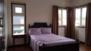 a bedroom with a bed and two windows at Angeles Private Pool Villa in Angeles +28 photos