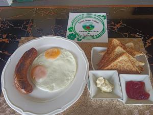 a plate with an egg and a sausage and toast at Green Acres Village in Moalboal