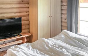 um quarto com uma cama e uma televisão de ecrã plano em Cozy Home In Slen With Sauna em Stöten