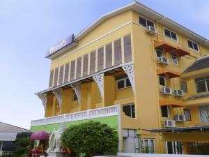 a yellow building with a balcony on it at Sawasdee Sukhumvit Inn in Bangkok