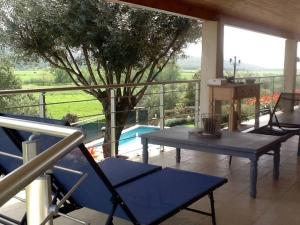 patio con mesa y sillas en el balcón en LE PALADIN Porto Pollo Villa privée avec piscine chauffée en Serra-di-Ferro