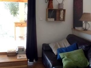 a living room with a black leather couch and a window at LE PALADIN Porto Pollo Villa privée avec piscine chauffée in Serra-di-Ferro