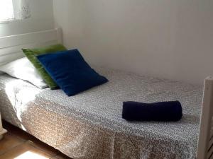 łóżko z dwoma niebieskimi poduszkami na górze w obiekcie LE PALADIN Porto Pollo Villa privée avec piscine chauffée w mieście Serra-di-Ferro