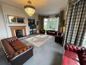 a living room with leather furniture and a fireplace at The Lloyd George in Caernarfon