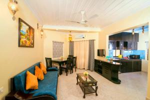 a living room with a blue couch and a table at 'Golden Sea Pearl' 1 bhk Beach apartment in Benaulim