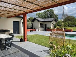 a patio with a table and chairs in a yard at Villa 5 chambres avec piscine, jacuzzi, terrain. in Ambronay