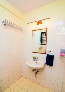 a bathroom with a sink and a mirror at 'Golden Sea Pearl' 1 bhk Beach apartment in Benaulim