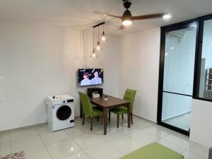 jadalnia ze stołem i zielonymi krzesłami w obiekcie Nice & Comfy Studio in Greenfield Regency w mieście Johor Bahru
