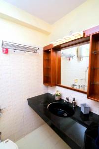a bathroom with a black sink and a mirror at 'Golden Sea Pearl' 1 bhk Beach apartment in Benaulim