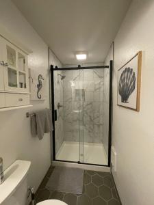 a bathroom with a shower with a glass door at Our Cozy Getaway in Ocean Park