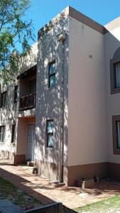 a white building with a shadow on the side of it at Broadway Self Catering Apartments in Durbanville