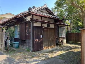 an old house with a wooden door and a fence at 桜山ノウチ in Zushi