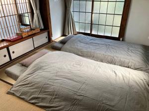 a bedroom with two beds and two windows at 桜山ノウチ in Zushi