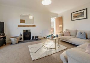 a living room with a couch and a table at Netherend in Oxwich