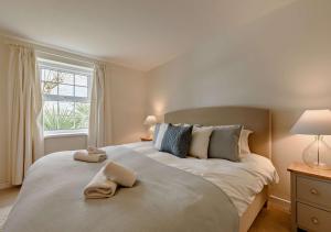 a bedroom with a large bed with two towels on it at Netherend in Oxwich