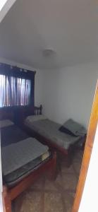 2 camas en una habitación con espejo en solo turistas en Salta