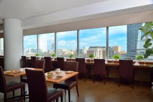 a restaurant with tables and chairs and large windows at Yokohama Sakuragicho Washington Hotel in Yokohama