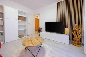 a living room with a tv and a coffee table at Luxe City in Rijeka