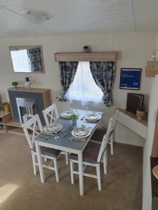 a dining table and chairs in a living room at Billing Aquadrome in Great Billing