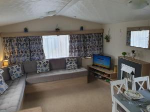 a living room with a couch and a tv at Billing Aquadrome in Great Billing