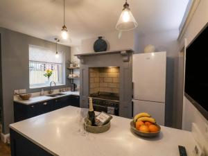 a kitchen with a bowl of fruit on a counter at Bumblebee Cottage in Beverley