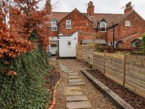 a stone path in front of a house at Bumblebee Cottage in Beverley