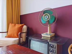 a fan sitting on top of a tv in a room at Walk-Up To SIAR - Children Not Allowed in Cameron Highlands