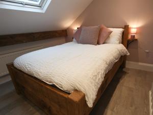 a bed with a wooden frame in a room at By the Tracks in Buxton