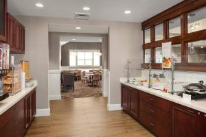 a kitchen with wooden cabinets and a dining room at Residence Inn Poughkeepsie in Poughkeepsie