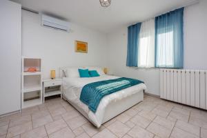 a bedroom with a bed and a window with blue curtains at Luxe Blue in Šmrika