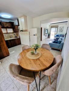 een keuken en eetkamer met een houten tafel en stoelen bij Your Home in Deir Ḥannā