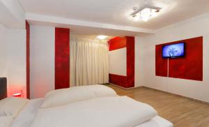 a bedroom with two beds and a tv on the wall at Hotel Alte Fabrik in Mettmann