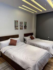 two beds in a room with white sheets at Villa 267 Residence in Cairo