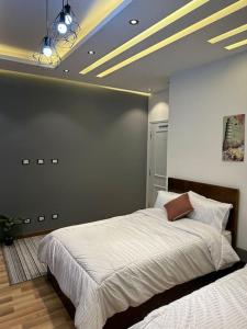 a bedroom with a large white bed with a ceiling at Villa 267 Residence in Cairo