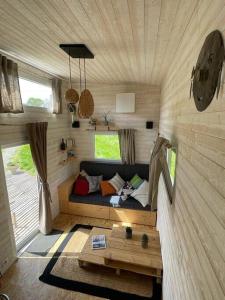 a room with a couch in a tiny house at Tiny house au cœur du bocage in Landelles-et-Coupigny