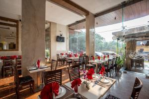 a restaurant with tables and chairs with red bows at Le Seasons Resort in Candolim