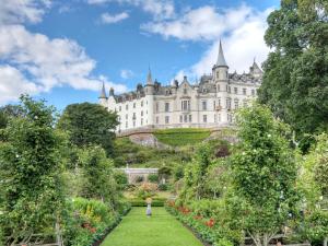 a castle with a garden in front of it at Dairy Cottage - Beaufort Estate in Belladrum