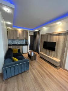 een woonkamer met een blauwe bank en een tv bij family apart hotel in Istanbul