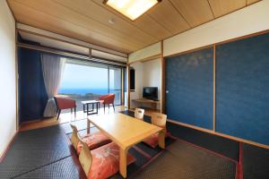 um quarto com uma mesa e uma sala de jantar em Yutorelo Atami em Atami