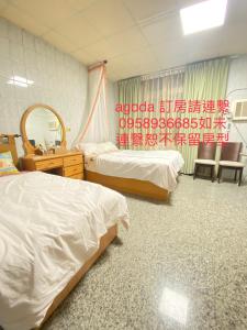 a hotel room with two beds and a mirror at Enoya Homestay III in Linbian