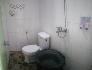 a bathroom with a black toilet and a shower at Bromo Tanjung in Tosari
