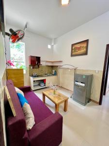 a living room with a purple couch and a table at Ngo Family Homestay in Hoi An