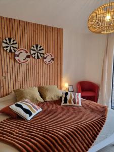 1 dormitorio con 1 cama grande y 1 silla roja en Lodge Cosy tout confort Lodge des Oliviers, en Ganges