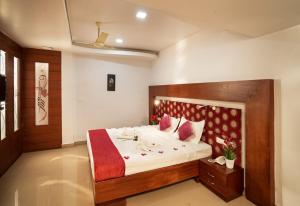 Empire Residency في Tiruvalla: غرفة نوم بسرير كبير مع اللوح الخشبي