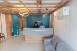 two men standing at a counter in a room at Hotel Aalia in Thanjāvūr