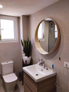 a bathroom with a sink and a toilet and a mirror at Piles Playa Beach Apartment in Piles