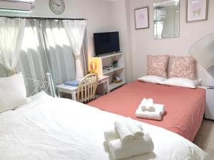 Habitación pequeña con 2 camas y TV. en COCO Nakameguro 202, en Tokio