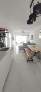 a white living room with a table and a couch at Casa da paz #2 in Vila Nova de Milfontes
